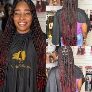 Femme avec de longues Box Braids bicolores (noir et rouge) aux extrémités bouclées, coiffure protectrice.