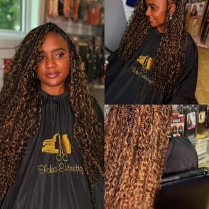 Femme avec des Boho Goddess Braids longues et ondulées, mèches châtain clair et bouclées, coiffure protectrice.